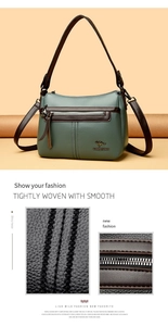 Detail view of dark green pebbled leather texture with brown trim and metallic kangaroo logo