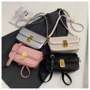 Flat lay of four textured leather crossbody bags in silver, cream, pink, and black colors