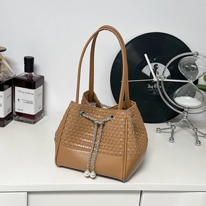 Brown crocodile texture bucket bag with pearl drawstring and silver chain detail