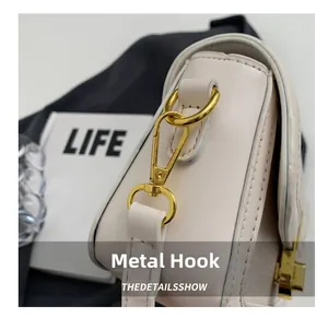 Detailed close-up of premium gold-tone hardware clasp and white leather bag texture