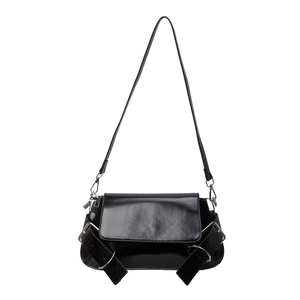 Glossy black patent leather crossbody bag with silver eyelet straps on white background