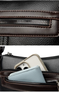 Detailed view of black litchi grain leather bag with smooth zipper and phone storage