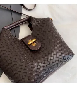 Dettaglio della trama intrecciata marrone scuro e chiusura a girello in ottone antico