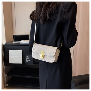 Close-up of off-white lychee pattern crossbody bag with a vintage gold metal lock