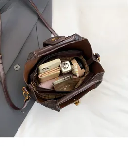 Dettaglio della borsa a secchiello in pelle intrecciata marrone con interno spazioso