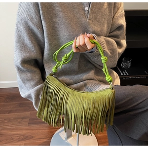 Close-up of lime green suede fringe handbag with woven handle and bohemian tassel details