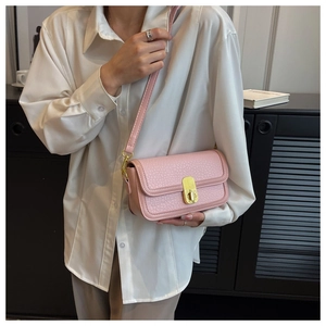 Detail of pink lychee leather crossbody bag with golden twist lock and thin strap