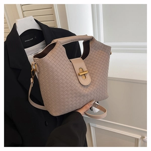 Detail of beige woven leather shoulder bag with gold metal twist lock and soft texture