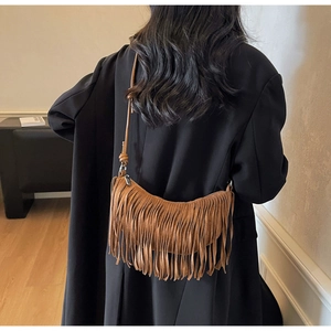 Brown suede crescent bag featuring stylish long tassels and adjustable shoulder strap