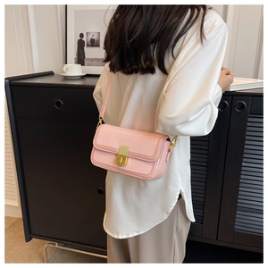 Pink textured leather crossbody bag with golden metal buckle worn with a white shirt