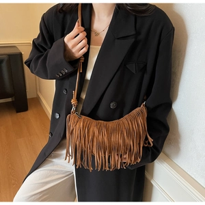 Close-up detail of the brown suede fringe crescent bag with bohemian tassel accents