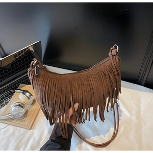 Macro view of dark brown suede crescent hobo bag with long fringe tassels and zipper