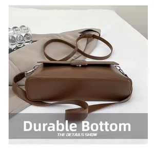 Detailaufnahme der strapazierfähigen Bodennähte und Lederstruktur der braunen Tasche