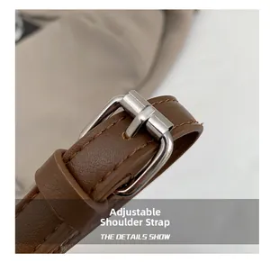 Detail eines verstellbaren braunen Leder-Schultergurts mit polierter Metallschnalle