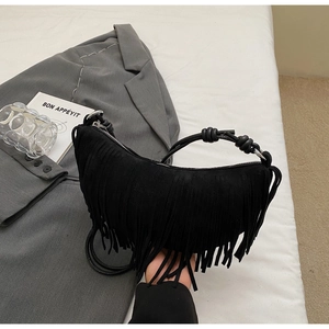 Detail of black crescent suede bag featuring dense long tassels and a knotted handle