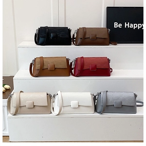 Detailansicht von sieben minimalistischen Umhängetaschen auf weißem Etagen-Display