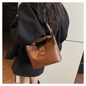 Detail of caramel brown woven leather texture on a stylish quilted shoulder bag