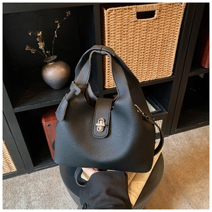 Close-up of the black bucket bag showing the premium lychee grain texture and metal lock