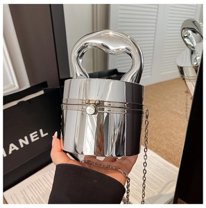 Detail of silver metallic cylindrical handbag with curved handle and chain strap