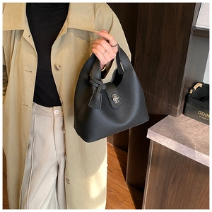 Close-up of black litchi grain leather bucket bag with silver metal twist lock detail