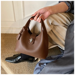 Close-up of litchi grain brown leather bucket bag with silver metal swivel lock clasp