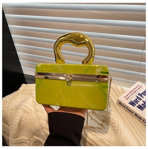 Detail of light green marble acrylic evening clutch with gold irregular handle and chain
