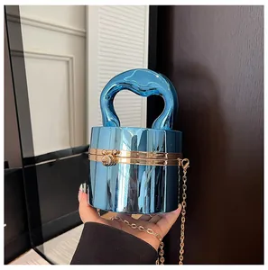 Detailed macro view of the electric blue mirrored cylindrical handbag with gold metal lock