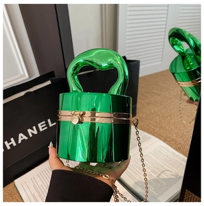 Detail of green metallic bucket bag with embossed texture and gold hardware clasp