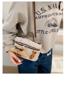 Détail du sac boîte en peluche crème avec breloques croissant et lapin porté épaule