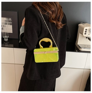 Lime green marble acrylic evening clutch bag with gold handle and chain on black blazer