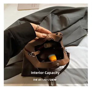 Detailed interior view of brown bucket bag showing large capacity and inner pockets