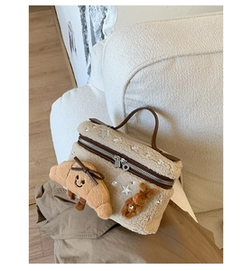 Gros plan du sac boîte en peluche blanche avec étoiles argentées et pendentifs oursons