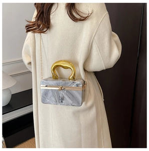 Detail of grey marble acrylic evening clutch with gold metal handle and chain strap