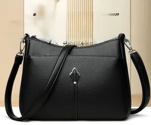 Detail of black pebbled leather handbag with silver petal hardware and stitching