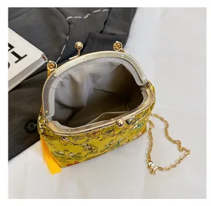 Interior view of yellow evening bag showing herringbone lining and metal chain strap