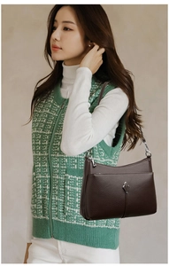 Detail of dark brown lychee pattern leather shoulder bag with silver zipper and buckle