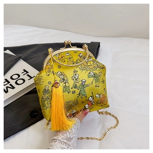 Detail of yellow silk clutch with traditional embroidery and golden chain strap