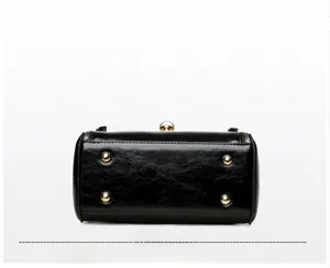 Detail of handbag base with four golden metal feet and precise stitching on black leather