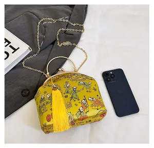 Size comparison of yellow Chinese style satin evening bag with traditional embroidery