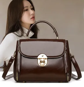 Close-up of vintage dark brown faux leather handbag with golden lock and metal handle