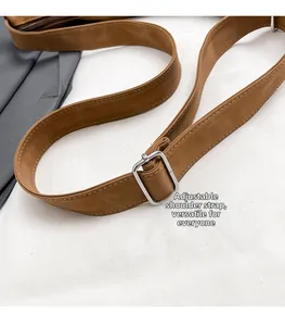 Close-up of adjustable brown leather shoulder strap with silver square metal buckle