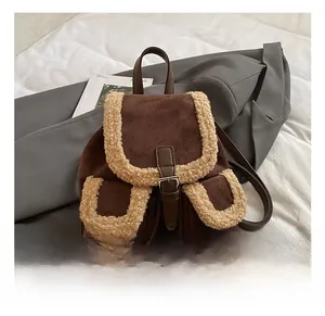 Detail of vintage brown suede backpack with faux shearling trim and leather buckle closures