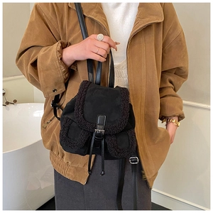 Detail of mini black backpack featuring lamb wool trim and premium metal buckle closure