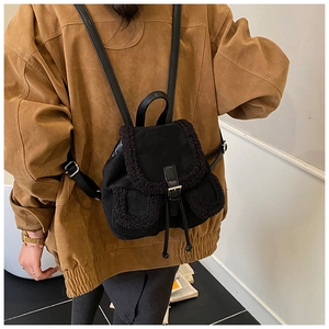 Detail of mini backpack featuring plush faux fur trim and drawstring closure with metal buckle
