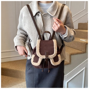 Close-up of retro backpack with brown faux suede and white faux fur trim detail