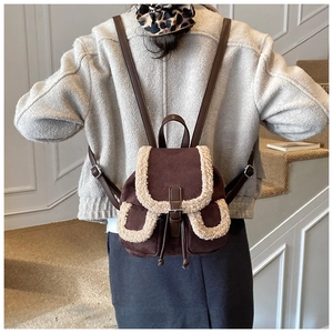 Detail of dark brown faux suede backpack featuring white faux shearling trim and drawstrings