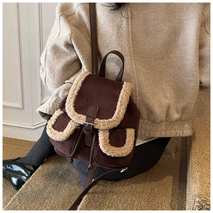 Detail of vintage suede backpack with faux shearling trim and brown leather straps