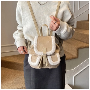 Detailed view of winter mini backpack with faux shearling trim and leather buckle straps