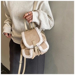 Detail of beige suede backpack with white faux fur trim and drawstring buckle closure