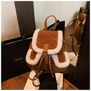 Detail of vintage brown suede backpack with white faux shearling trim and buckle straps